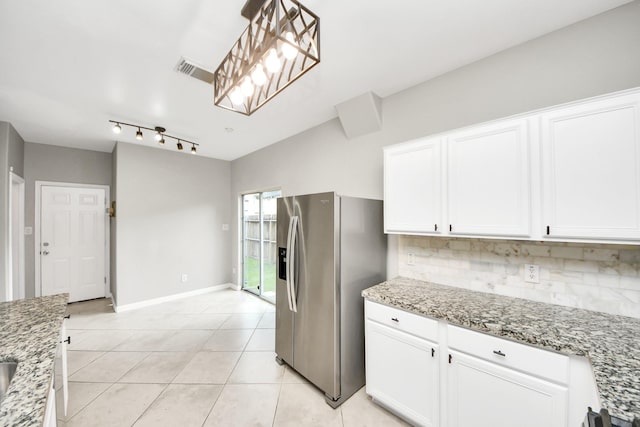 2214 Naomi St, Houston, TX 77054 - kitchen featuring stainless steel fridge, decorative backsplash, white cabinets, light stone counters, and light tile patterned floors