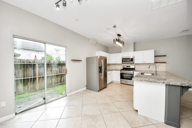 2214 Naomi St, Houston, TX 77054 - kitchen featuring stainless steel appliances, a peninsula, light stone countertops, backsplash, and white cabinets