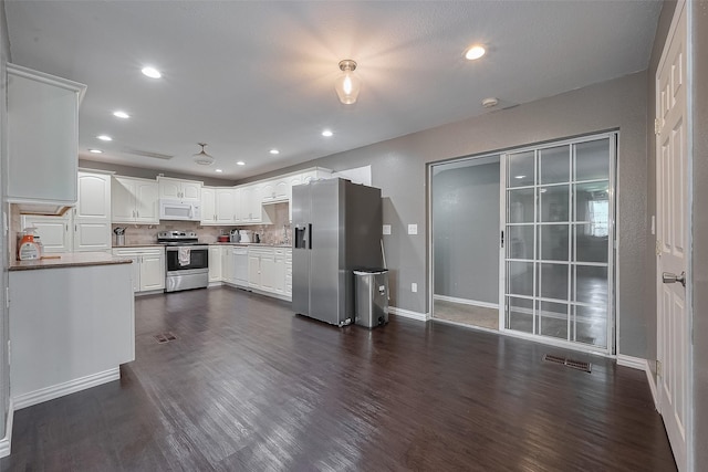 1725 County Road 244e, Brazoria, TX 77422 - kitchen with stainless steel appliances, dark wood-type flooring, white cabinets, recessed lighting, and decorative backsplash