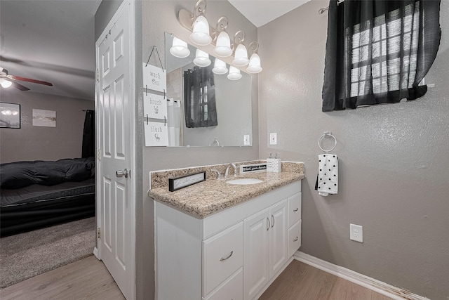1725 County Road 244e, Brazoria, TX 77422 - bathroom featuring wood finished floors, a ceiling fan, vanity, ensuite bathroom, and a textured wall