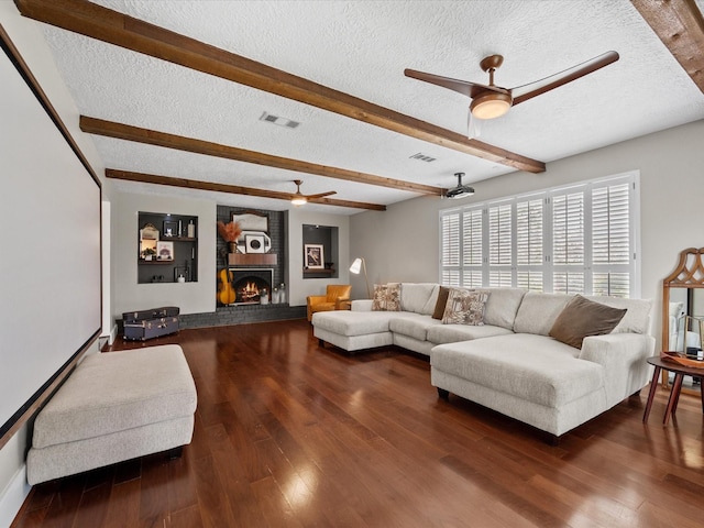 16434 Heatherdale Dr, Houston, TX 77059 - living area with ceiling fan, a textured ceiling, beamed ceiling, wood finished floors, and a brick fireplace