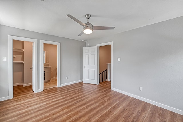 8125 Eastover St Unit Ab, Houston, TX 77028 - unfurnished bedroom featuring a spacious closet, light wood-style flooring, a closet, ensuite bath, and a ceiling fan