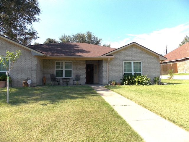 1501 E Pecan St, Brenham, TX 77833 - ranch-style home featuring a front yard, brick siding, and a shingled roof
