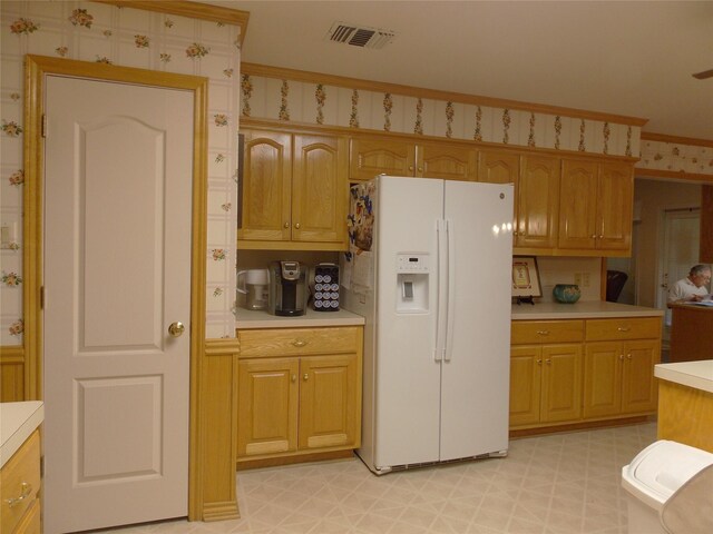 1501 E Pecan St, Brenham, TX 77833 - kitchen featuring white fridge with ice dispenser, light countertops, light floors, and ornamental molding