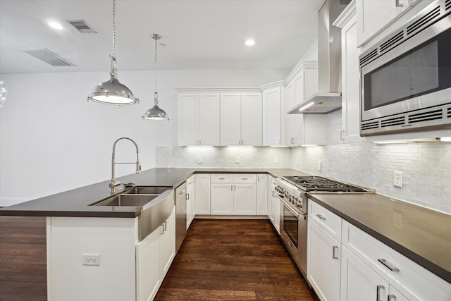 2509 Dorrington Blvd Unit B, Houston, TX 77030 - kitchen featuring appliances with stainless steel finishes, wall chimney exhaust hood, a peninsula, dark countertops, and backsplash