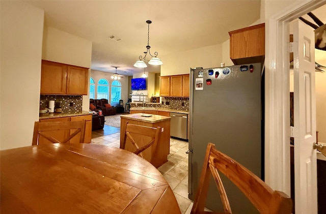 913 S Belle Dr, Angleton, TX 77515 - kitchen with appliances with stainless steel finishes, backsplash, a center island, and brown cabinets