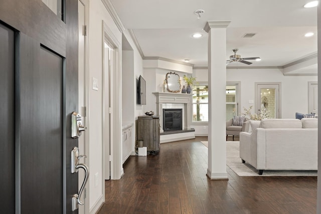 5743 Braesheather Dr, Houston, TX 77096 - living area with a glass covered fireplace, ornate columns, a ceiling fan, ornamental molding, and dark wood-type flooring