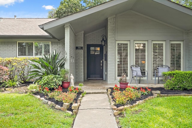 5743 Braesheather Dr, Houston, TX 77096 - entrance to property featuring brick siding, roof with shingles, and a lawn