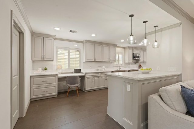 5743 Braesheather Dr, Houston, TX 77096 - kitchen with stainless steel microwave, ornamental molding, pendant lighting, recessed lighting, and a peninsula