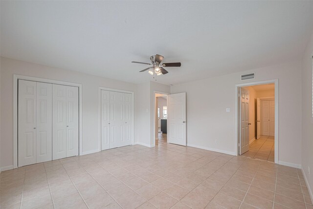 3810 Marlin Ln, La Porte, TX 77571 - unfurnished bedroom with light tile patterned floors, multiple closets, and a ceiling fan