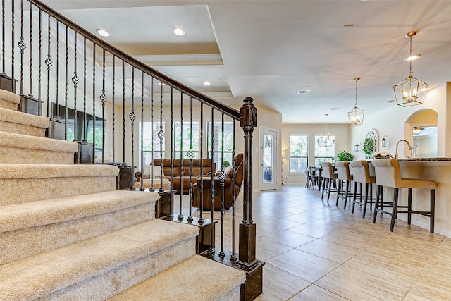 20910 Cordell Landing Dr, Richmond, TX 77407 - stairs with tile patterned flooring, arched walkways, recessed lighting, and a chandelier