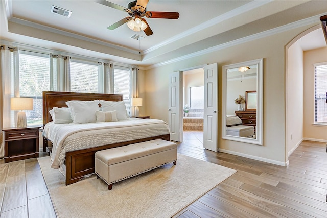 20910 Cordell Landing Dr, Richmond, TX 77407 - bedroom with a tray ceiling, crown molding, light wood finished floors, arched walkways, and ensuite bathroom