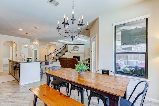20910 Cordell Landing Dr, Richmond, TX 77407 - dining area featuring arched walkways, a chandelier, recessed lighting, light tile patterned flooring, and stairs