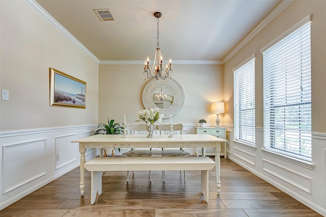 20910 Cordell Landing Dr, Richmond, TX 77407 - dining room with a chandelier, wainscoting, ornamental molding, a decorative wall, and light wood-style floors