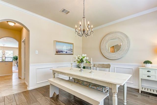 20910 Cordell Landing Dr, Richmond, TX 77407 - dining area with a chandelier, arched walkways, crown molding, a wainscoted wall, and wood finished floors