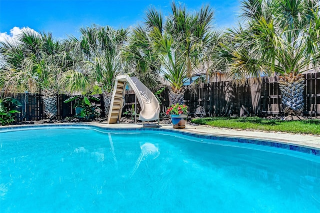 20910 Cordell Landing Dr, Richmond, TX 77407 - view of swimming pool with a water slide and a fenced backyard