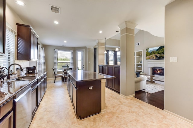 5409 Aroma Knoll Ln, Rosharon, TX 77583 - kitchen featuring stainless steel dishwasher, dark stone counters, dark brown cabinets, a lit fireplace, and recessed lighting