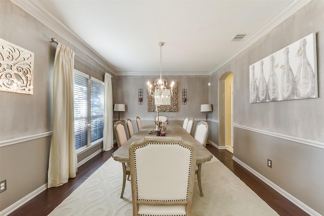 5409 Aroma Knoll Ln, Rosharon, TX 77583 - dining space featuring a chandelier, dark wood finished floors, crown molding, and arched walkways