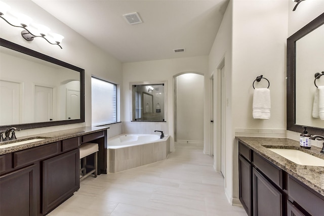 5409 Aroma Knoll Ln, Rosharon, TX 77583 - bathroom with two vanities, a bath, and a walk in shower
