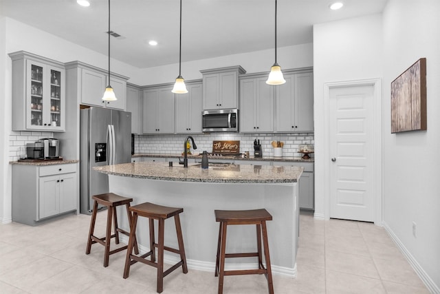 222 Speckled Woods Pl, Conroe, TX 77318 - kitchen featuring stainless steel appliances, gray cabinetry, stone counters, decorative backsplash, and recessed lighting