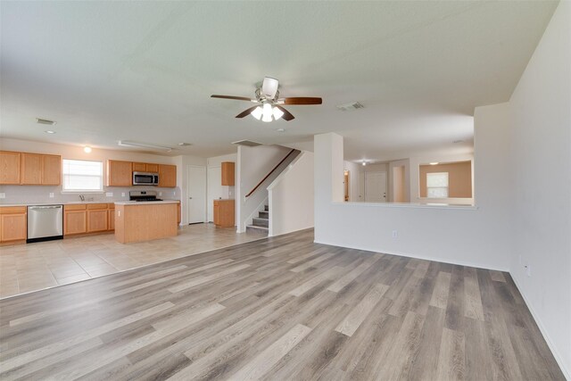 2614 Skyview Shadows Ct, Houston, TX 77047 - unfurnished living room featuring stairs, light wood finished floors, and ceiling fan