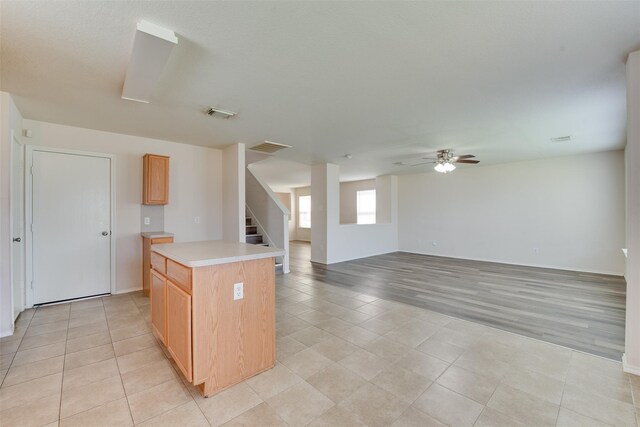 2614 Skyview Shadows Ct, Houston, TX 77047 - kitchen featuring light countertops, a ceiling fan, a center island, light tile patterned floors, and open floor plan
