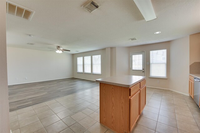 2614 Skyview Shadows Ct, Houston, TX 77047 - kitchen featuring light tile patterned floors, a ceiling fan, a textured ceiling, dishwasher, and a center island