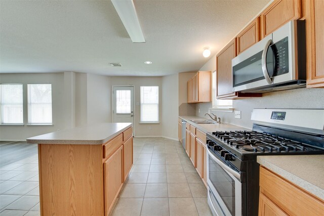 2614 Skyview Shadows Ct, Houston, TX 77047 - kitchen featuring appliances with stainless steel finishes, light tile patterned flooring, a kitchen island, light countertops, and recessed lighting