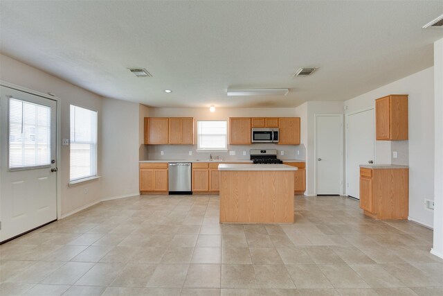 2614 Skyview Shadows Ct, Houston, TX 77047 - kitchen featuring stainless steel appliances, light countertops, a kitchen island, light tile patterned floors, and recessed lighting