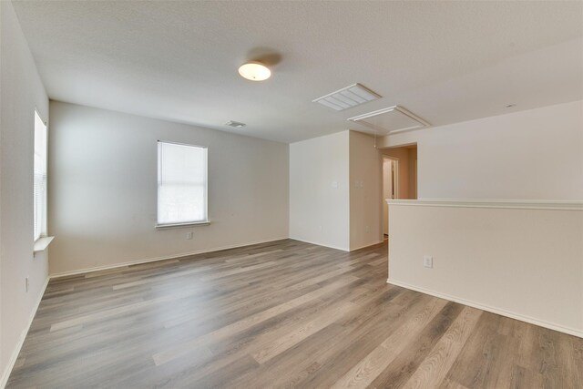 2614 Skyview Shadows Ct, Houston, TX 77047 - empty room featuring attic access, plenty of natural light, and wood finished floors