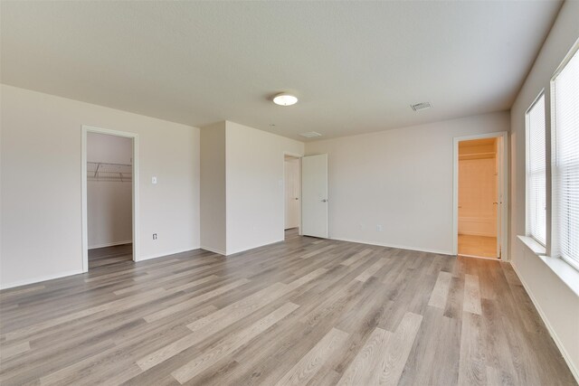 2614 Skyview Shadows Ct, Houston, TX 77047 - unfurnished bedroom featuring light wood-type flooring, a spacious closet, and a closet