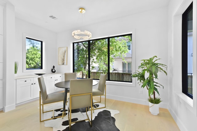 5115 Maple St, Houston, TX 77401 - dining area featuring healthy amount of natural light, light wood finished floors, and a chandelier
