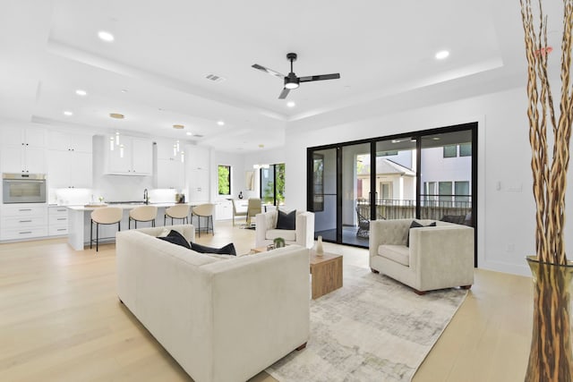 5115 Maple St, Houston, TX 77401 - living room with a raised ceiling, light wood-type flooring, recessed lighting, and a ceiling fan