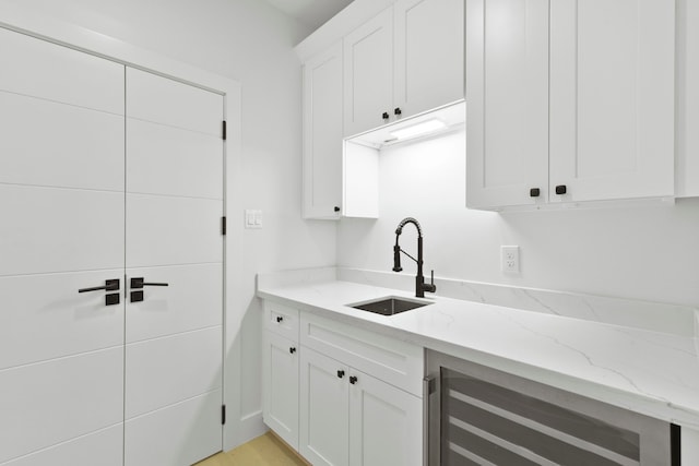 5115 Maple St, Houston, TX 77401 - kitchen with beverage cooler, light stone countertops, and white cabinetry