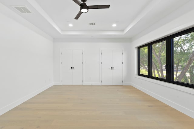 5115 Maple St, Houston, TX 77401 - unfurnished bedroom featuring a raised ceiling, multiple closets, light wood finished floors, recessed lighting, and a ceiling fan
