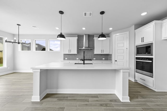 3244 Stingray Cove Dr, Katy, TX 77493 - kitchen featuring stainless steel oven, wall chimney exhaust hood, built in microwave, wood finish floors, and light countertops