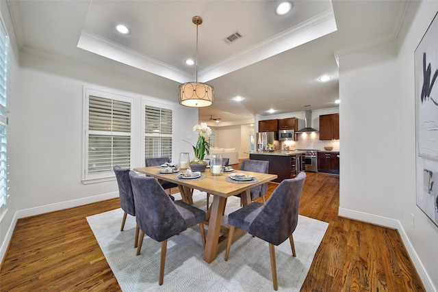 1822 Gardenia Dr, Houston, TX 77018 - dining space featuring dark wood-type flooring, a raised ceiling, ornamental molding, and recessed lighting