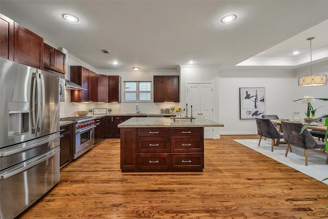 1822 Gardenia Dr, Houston, TX 77018 - kitchen with appliances with stainless steel finishes, ornamental molding, light wood-style floors, a center island, and decorative backsplash