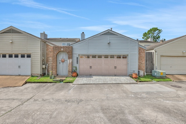 10918 Francoise Blvd, Houston, TX 77042 - mid-century home with brick siding, an attached garage, driveway, and a chimney