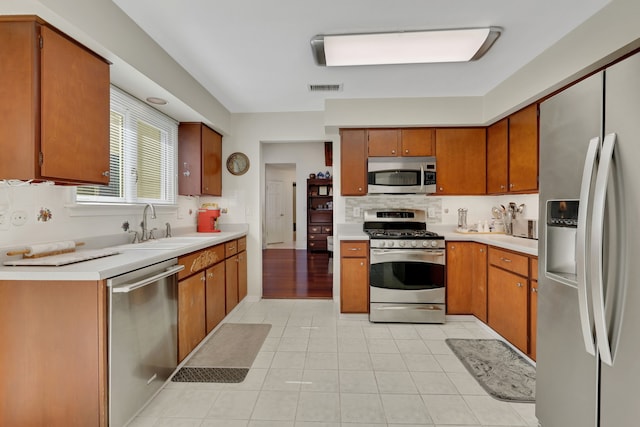 10918 Francoise Blvd, Houston, TX 77042 - kitchen featuring stainless steel appliances, tasteful backsplash, light countertops, and brown cabinetry
