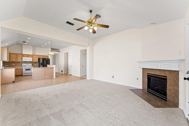 1627 Pebble Brk, Missouri City, TX 77459 - unfurnished living room featuring ceiling fan, light carpet, vaulted ceiling, a tile fireplace, and recessed lighting