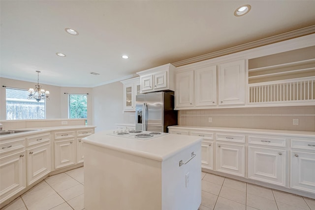 3110 Meadow Oak Dr, Houston, TX 77068 - kitchen featuring stainless steel fridge, light tile patterned floors, white electric stovetop, a center island, and crown molding