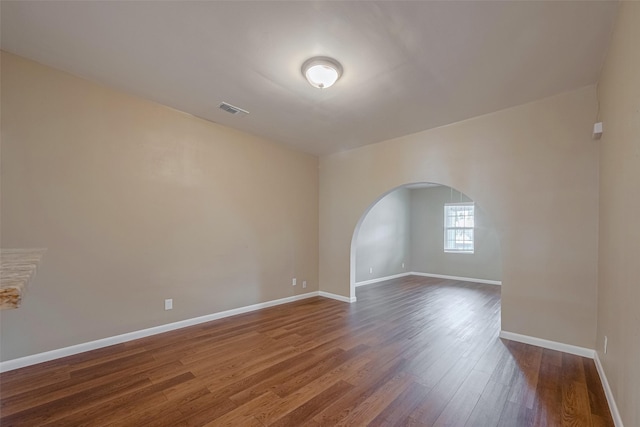 4519 N Main St, Houston, TX 77009 - unfurnished room featuring arched walkways and dark wood-type flooring