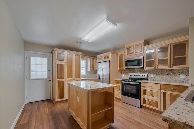 4519 N Main St, Houston, TX 77009 - kitchen with appliances with stainless steel finishes, open shelves, glass insert cabinets, and light wood-type flooring