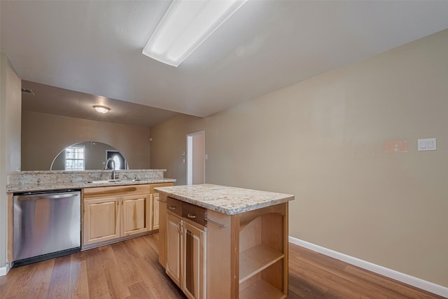 4519 N Main St, Houston, TX 77009 - kitchen featuring stainless steel dishwasher, light brown cabinetry, light wood-style floors, arched walkways, and a center island