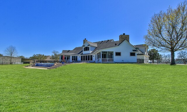 34210 Sanders Ranch Rd, Magnolia, TX 77355 - rear view of house featuring a pool, a yard, a chimney, and a sunroom
