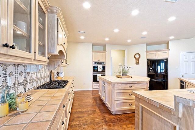 34210 Sanders Ranch Rd, Magnolia, TX 77355 - kitchen featuring black appliances, tile counters, a kitchen island, recessed lighting, and dark wood-style floors