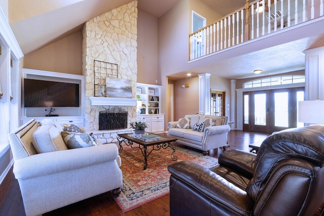34210 Sanders Ranch Rd, Magnolia, TX 77355 - living area with wood finished floors, high vaulted ceiling, a fireplace, decorative columns, and french doors