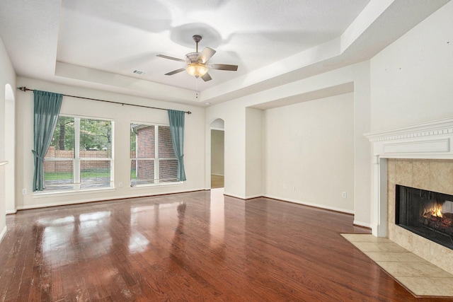 24006 Northshire Ln, Katy, TX 77494 - unfurnished living room with a raised ceiling, a tile fireplace, wood finished floors, and ceiling fan