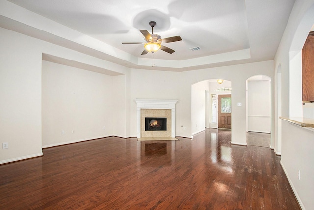 24006 Northshire Ln, Katy, TX 77494 - unfurnished living room with a raised ceiling, arched walkways, a ceiling fan, and wood finished floors